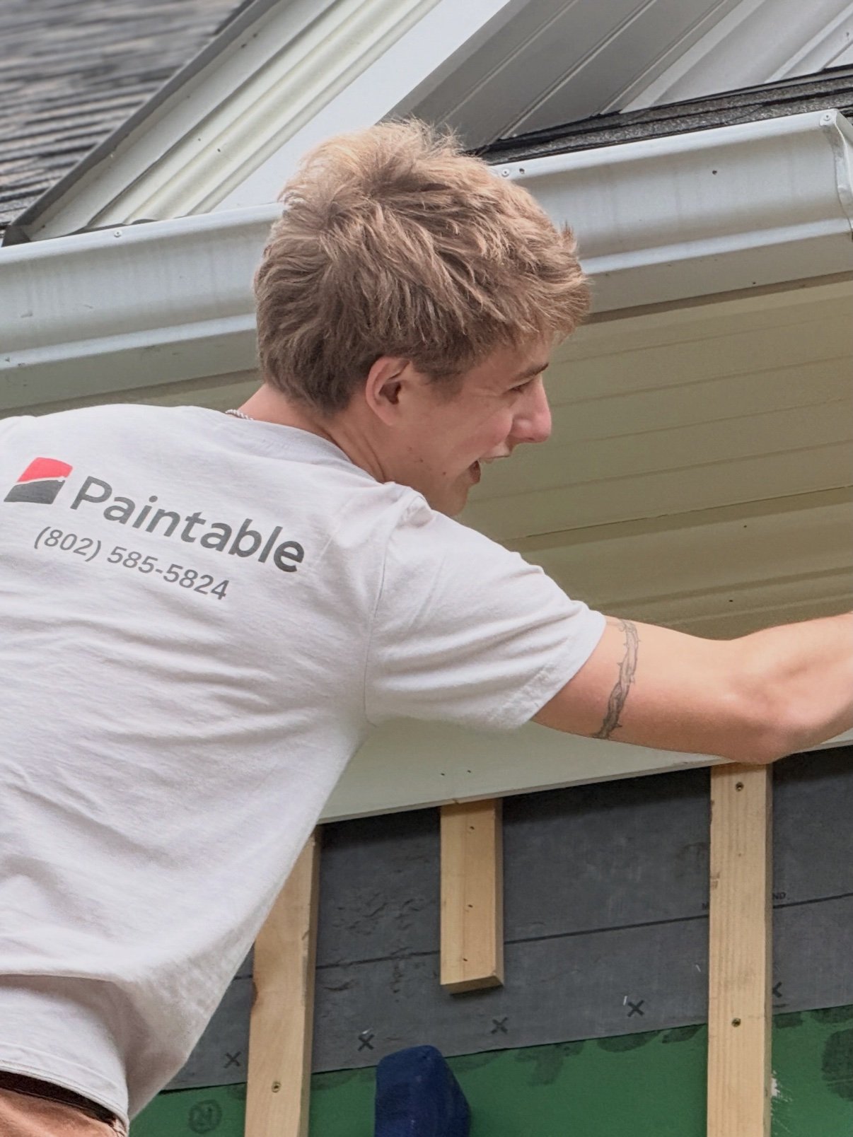 Paintable crew member painting a home exterior