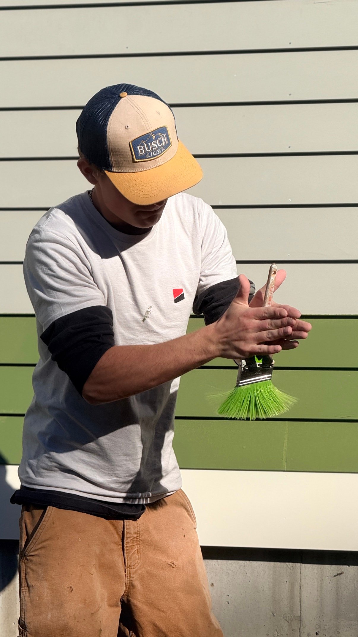 Paintable painter brushing paint on a Vermont home