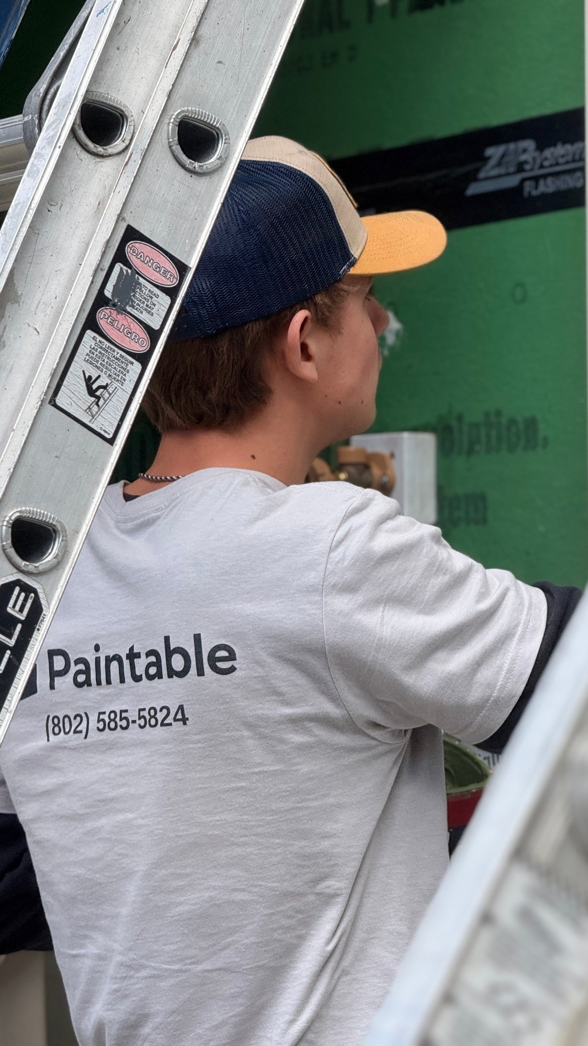 Paintable painter at work on a Vermont home exterior